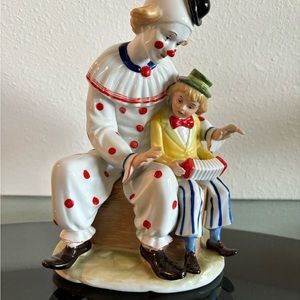 House of global art. Seated clown with young boy music box.